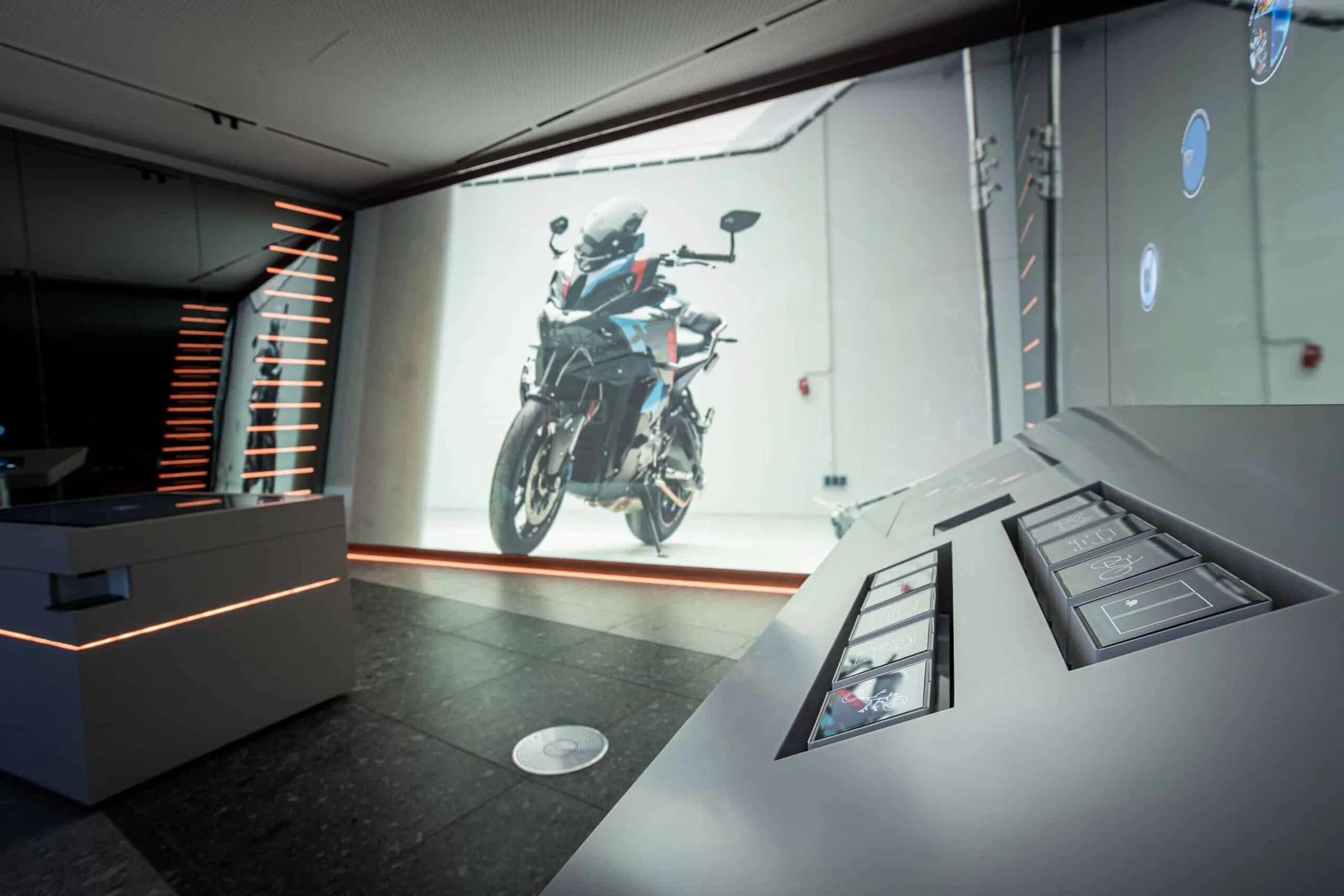 Immersiver Showroom mit Wandprojektion und Multitouch-Stationen