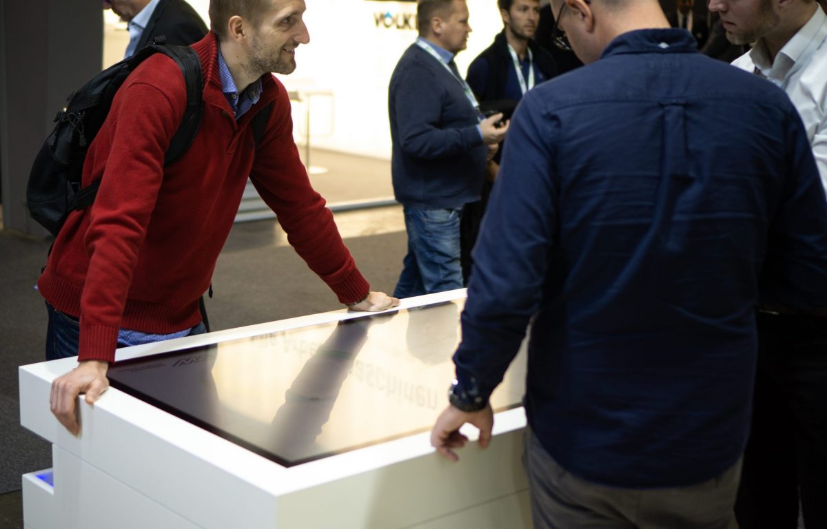 Messebesucher an interaktiven Vertriebs-Stationen