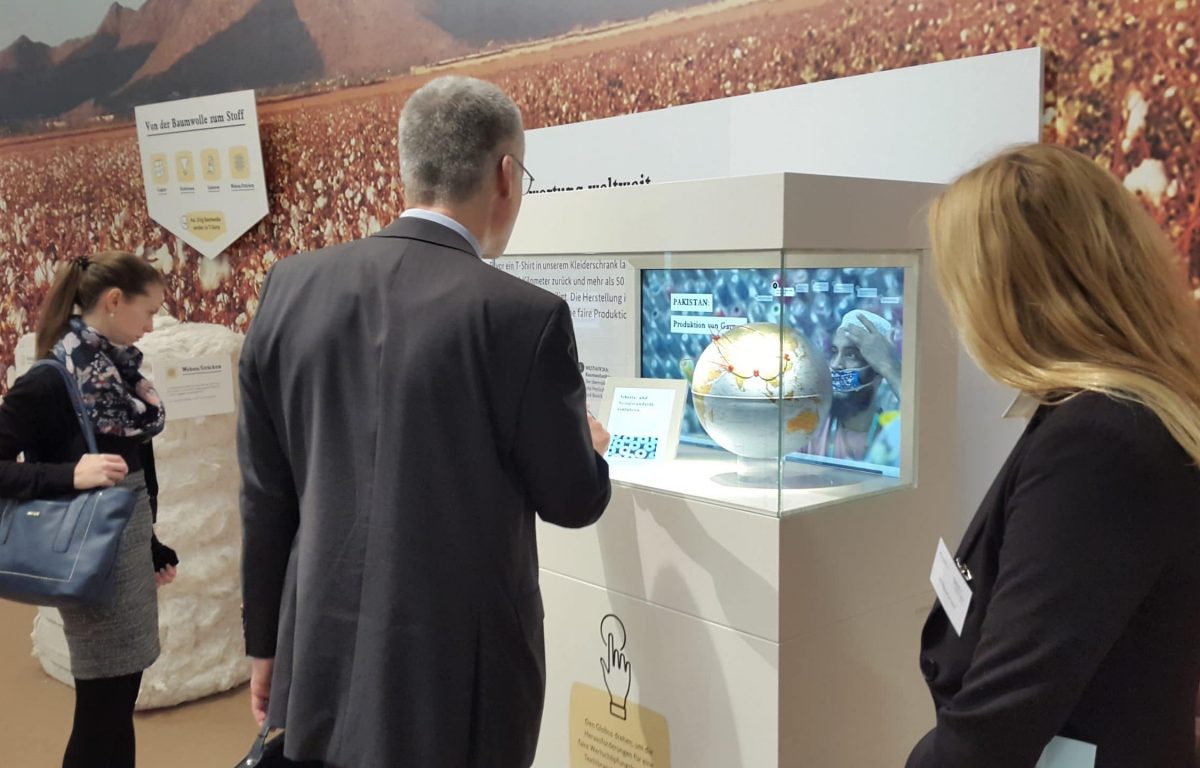 Messebesucher an der interaktiven Multitouch-Vitrine von Garamantis