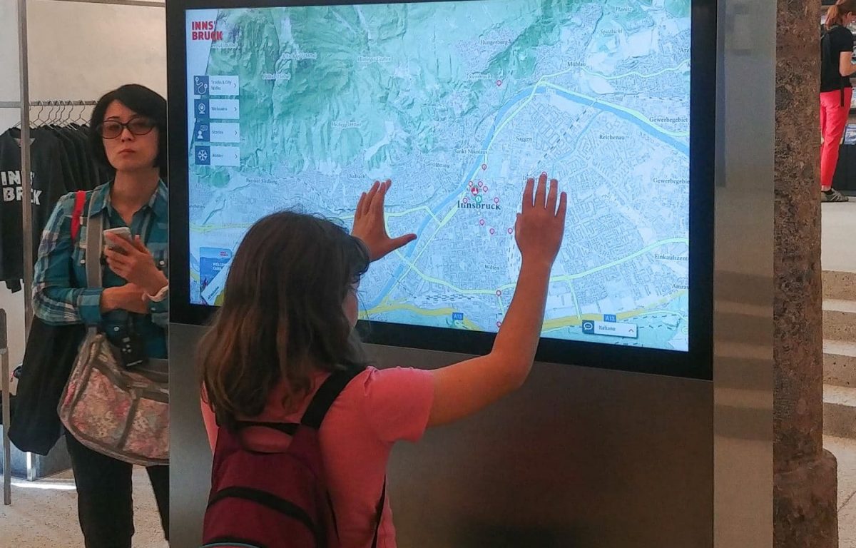 Besucher interagiert mit Karte auf Multitouch-Monitor in der Innsbruck Info