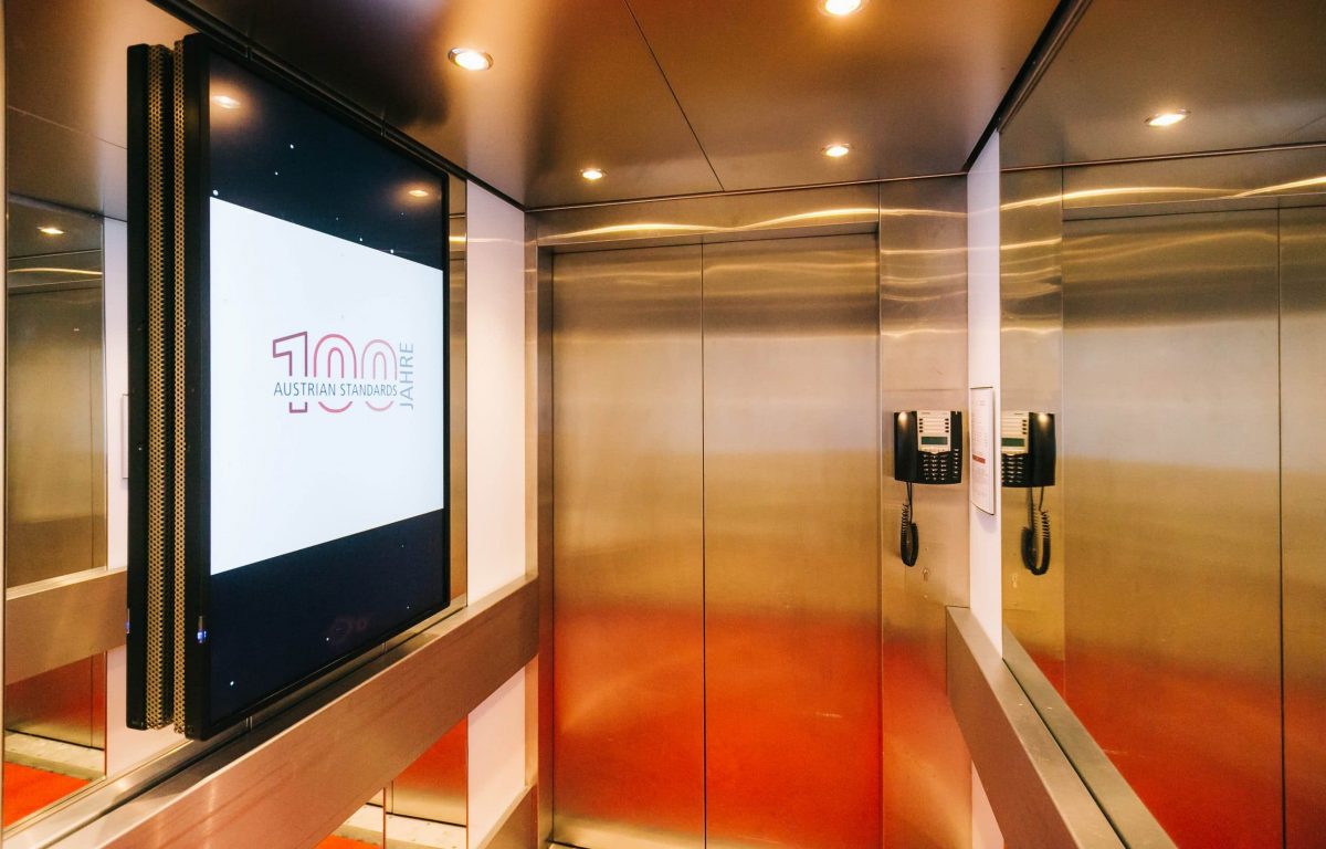 Aufzüge mit verglasten Screens, die Normen und animierte Informationen präsentieren