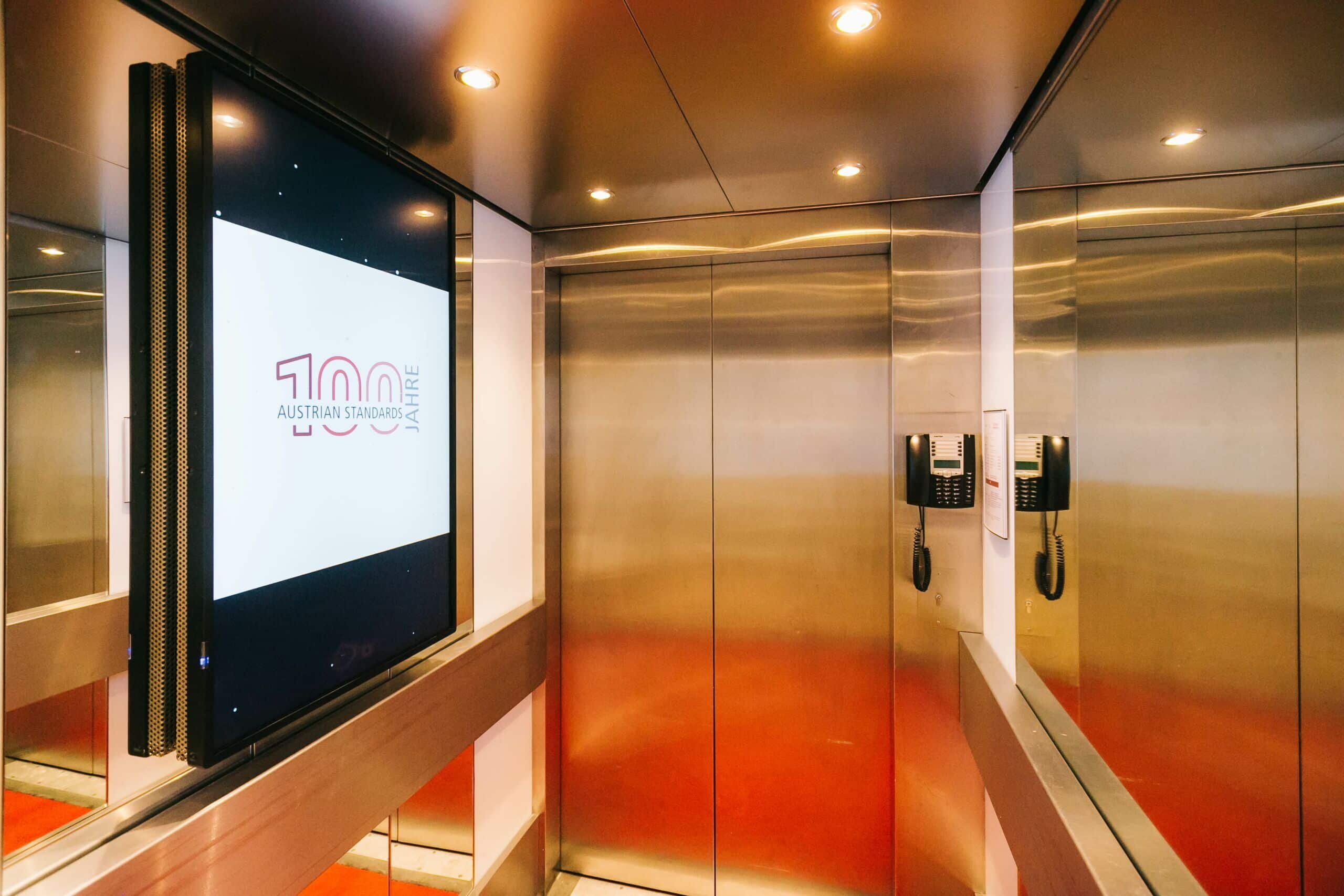 Aufzüge mit verglasten Screens, die Normen und animierte Informationen präsentieren