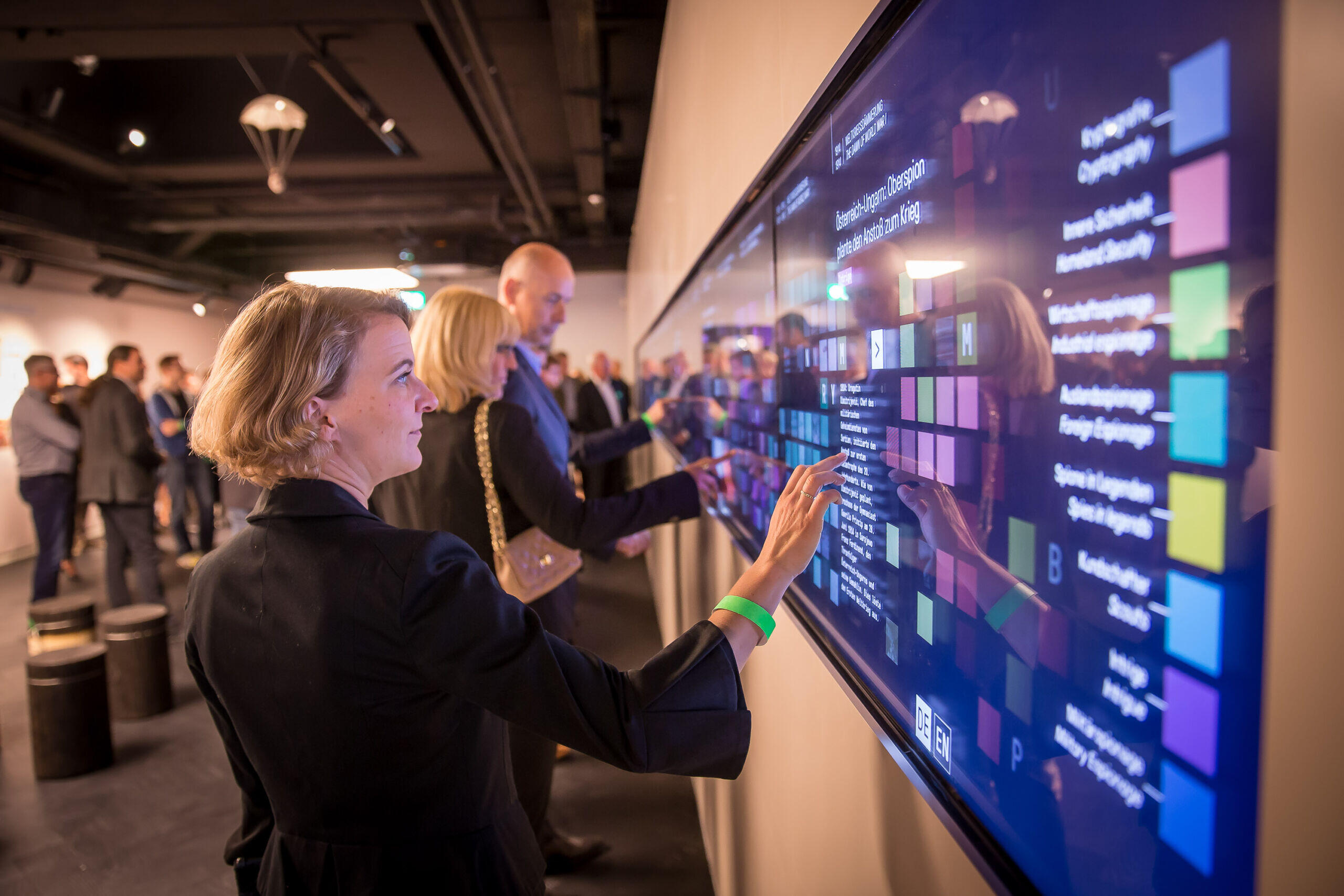Visitors interact with large multi-touch wall in the German Spy Museum Visitors interact with large multi-touch wall in the German Spy Museum