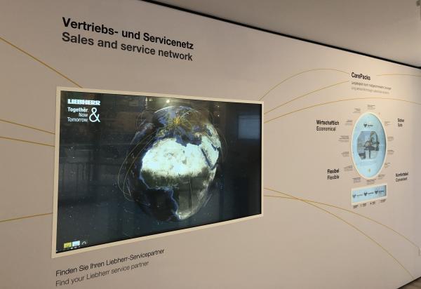 interaktive Messewand mit eingelassenen Multitouch-Screens und rundem Monitor