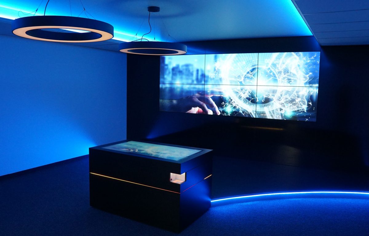 Multitouch-Tisch mit Bildschirmwand in interaktivem Showroom