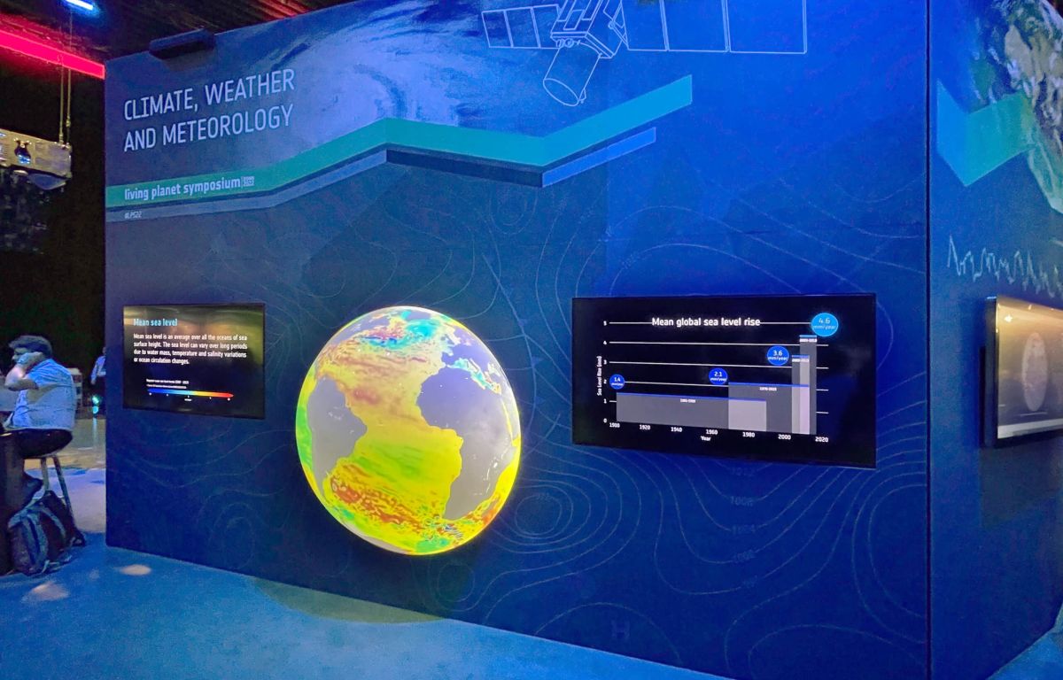 Interaktive Messewand mit 3D-Globus und integrierten Touchscreens